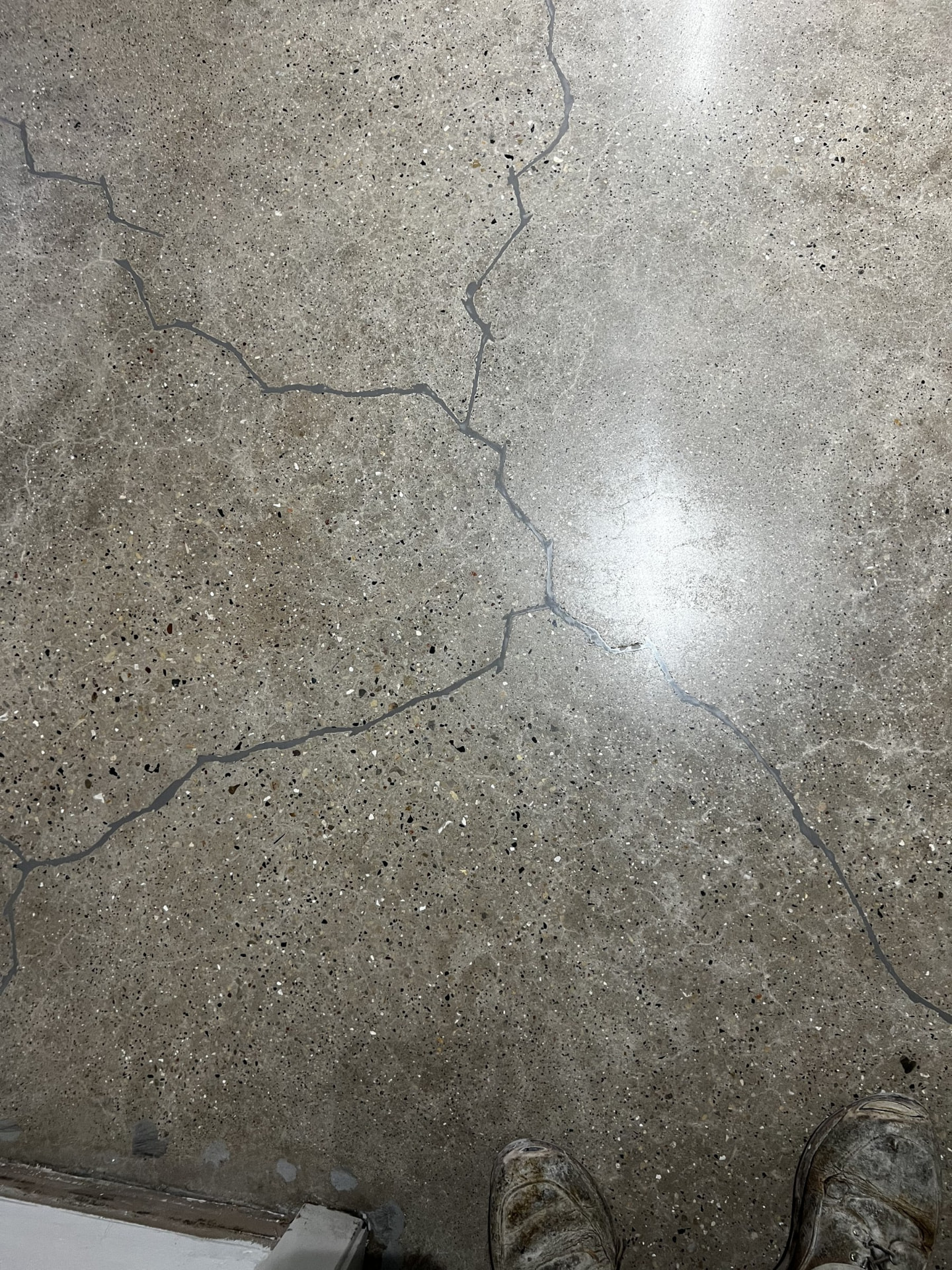 Repaired cracks in a concrete garage floor before polishing in Wisconsin