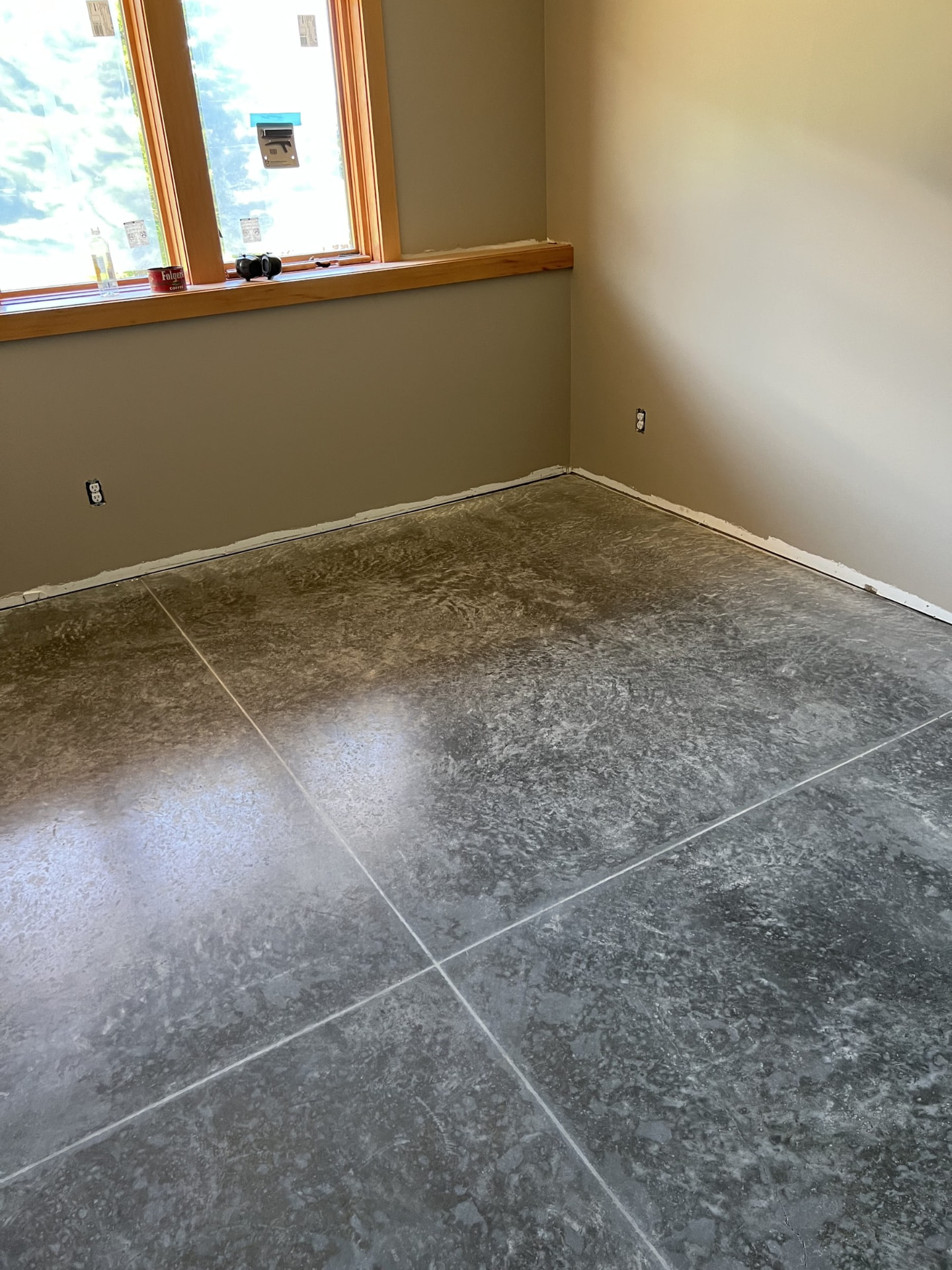 Dark polished concrete floor with a decorative tile-look finish in a Wisconsin home